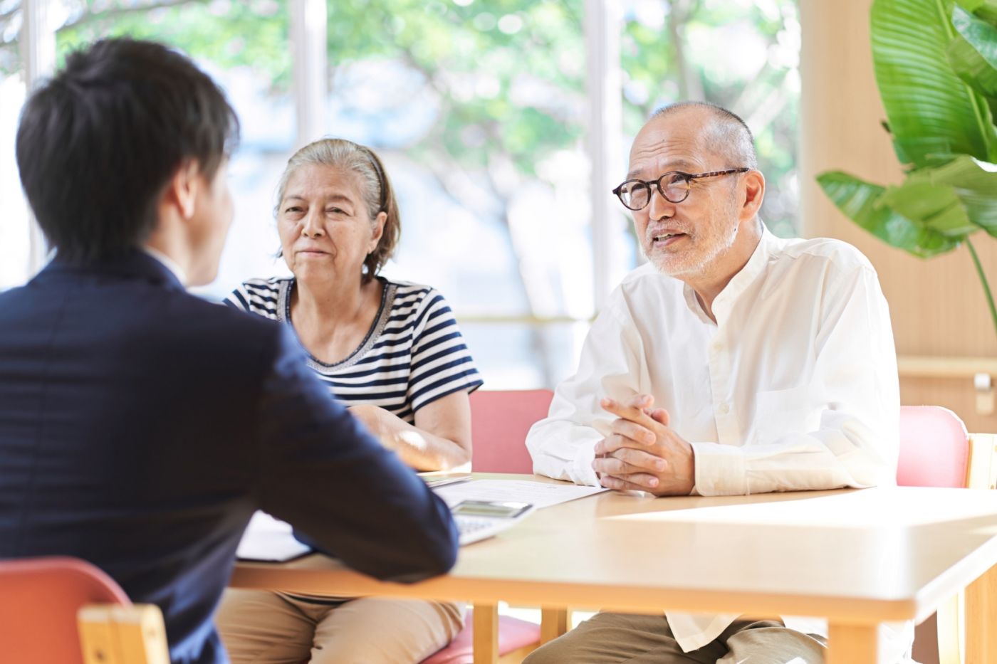 An older couple sits across a table from a younger man.