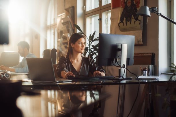 A woman using a computer in an office.