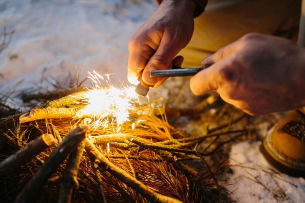 A close-up of a man starting a fire.